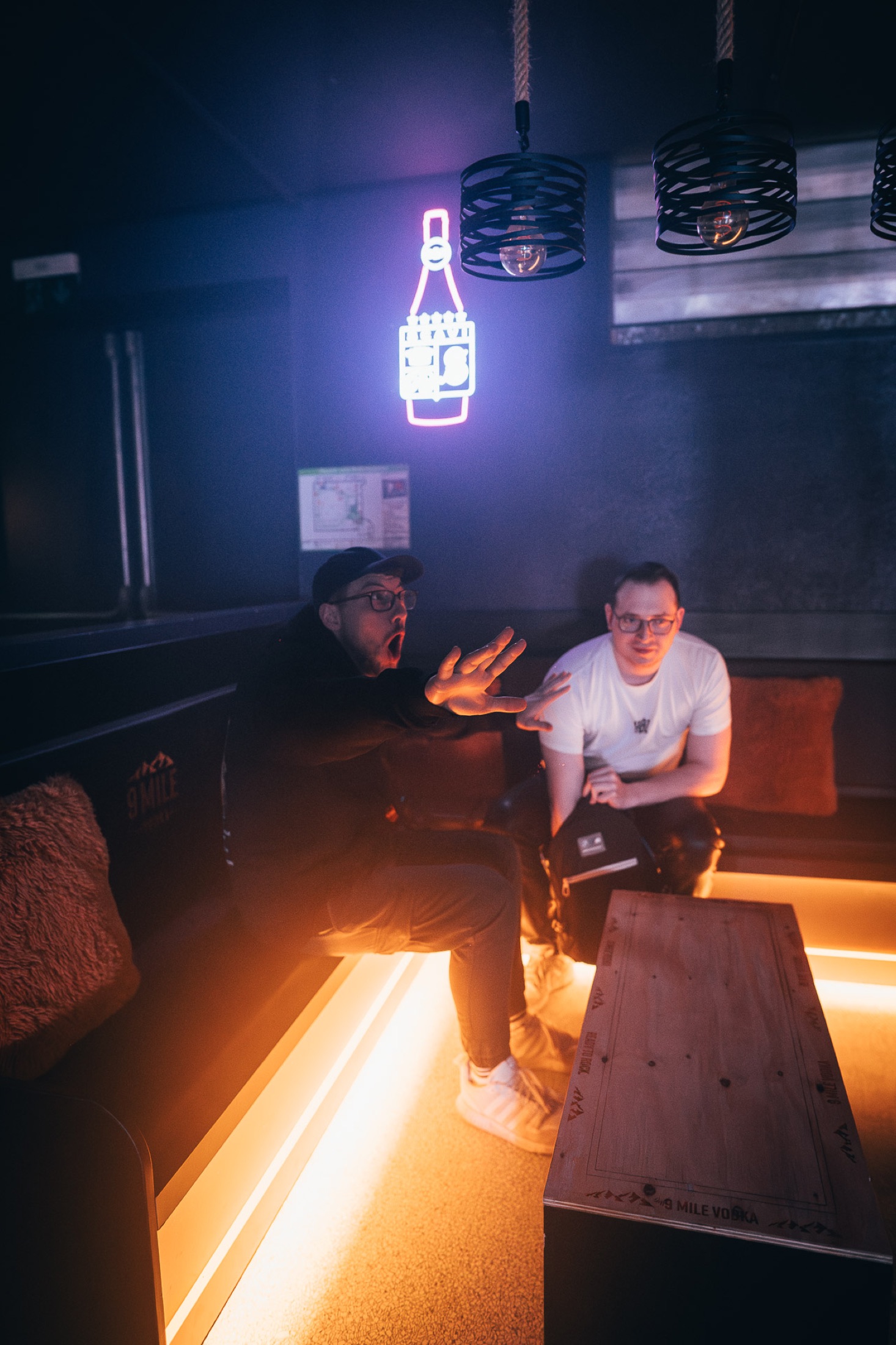 Zwei Personen in einer Lounge mit stimmungsvoller Neonbeleuchtung