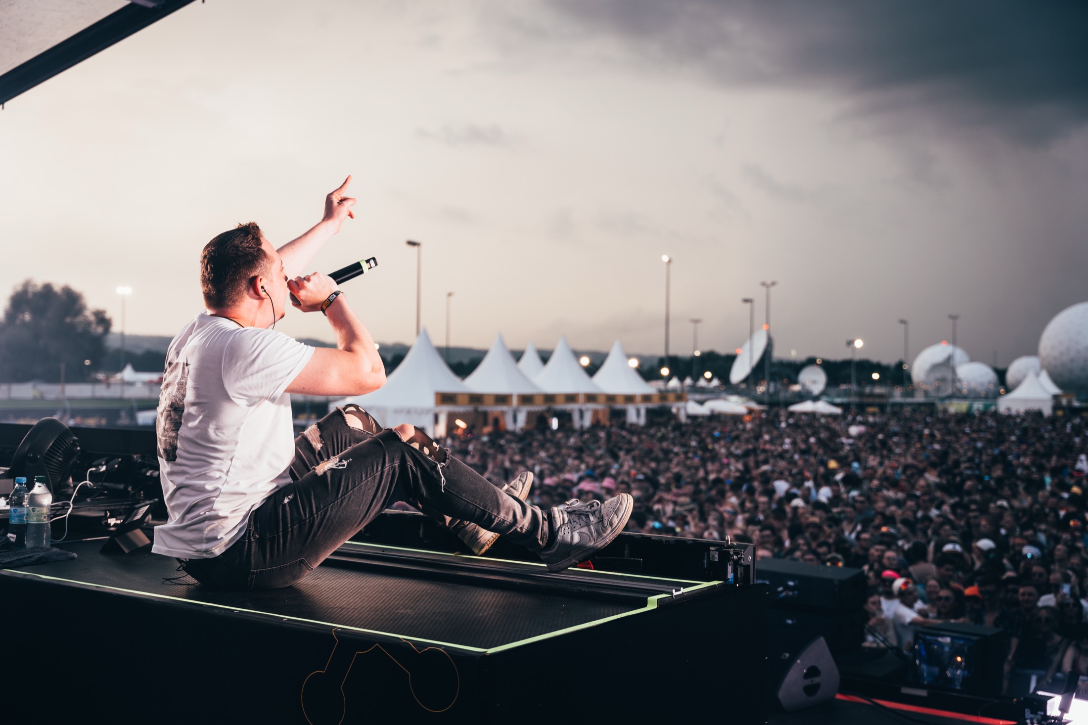 Künstler auf der Bühne zeigt auf die jubelnde Festivalmenge